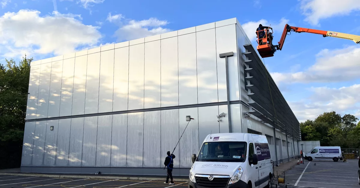 Clifton cleaning services using a hydraulic platform to clean the cladding on a building.