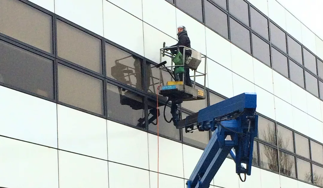 Clifton window cleaner on hydraulic platform cleaning cladding.