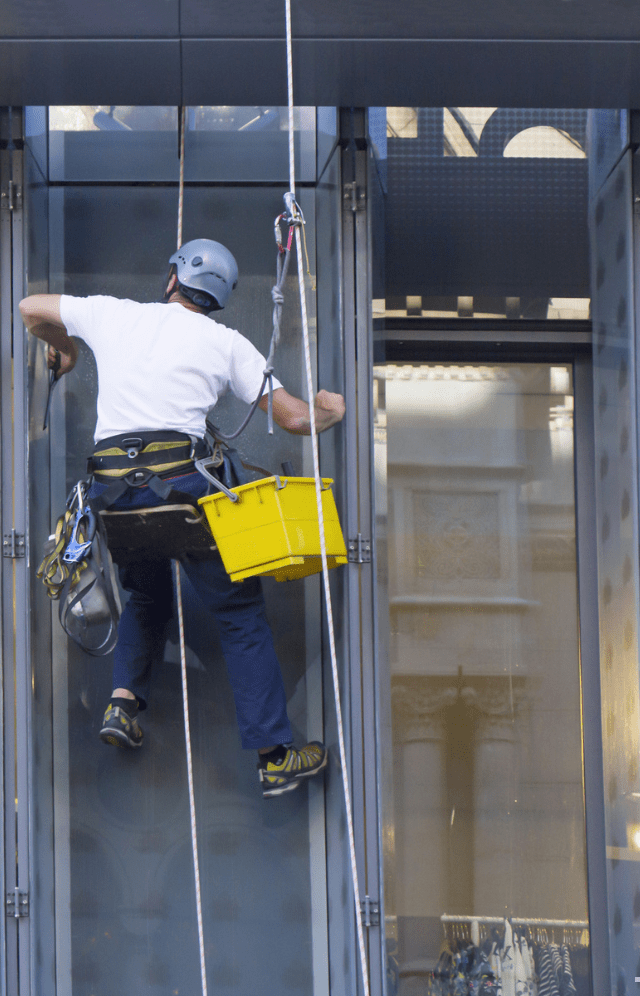 Man cleaning windows by rope access