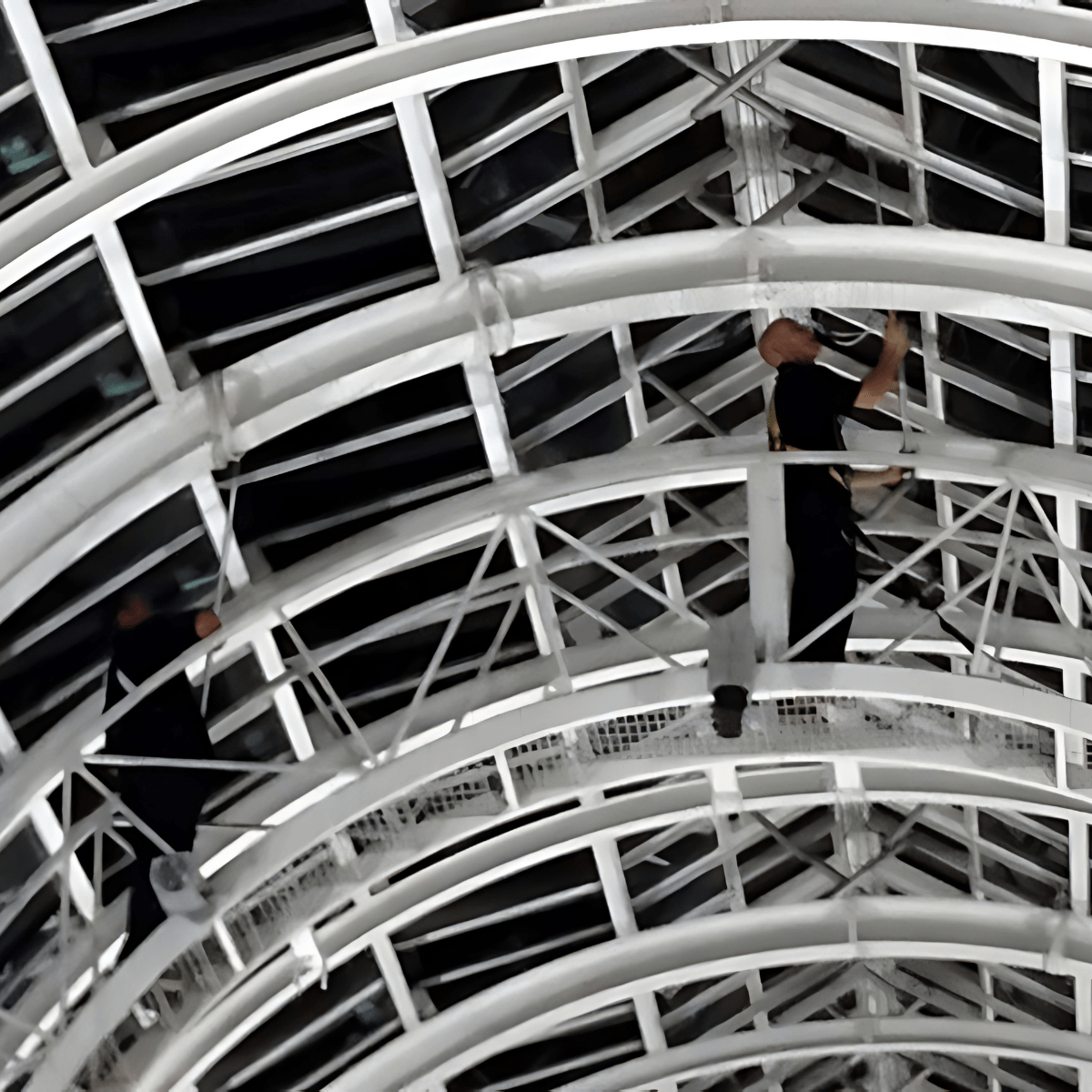 Man on high platform cleaning windows.