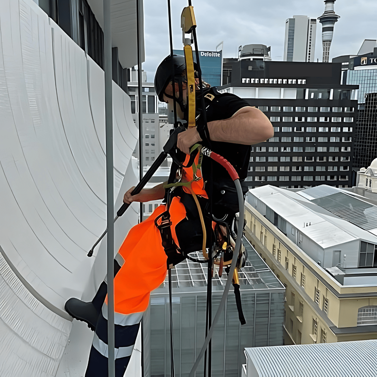 Man cleaning external building cladding.