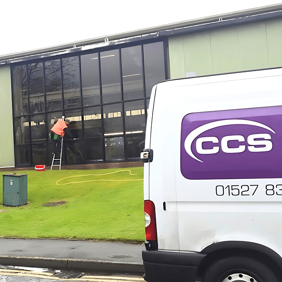 Man cleaning commercial windows van outside.